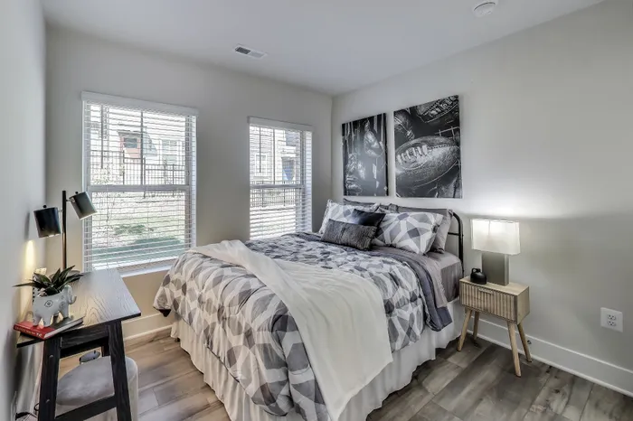 Cozy bedroom featuring large windows, modern decor, and plush bedding for ultimate comfort and relaxation.