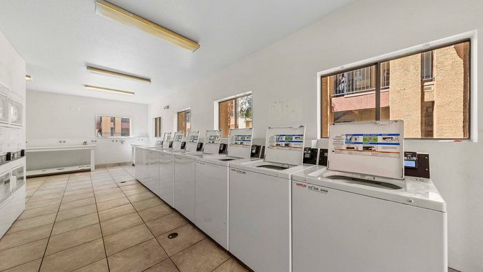 Bright and airy laundry room with multiple washing machines and ample natural light.