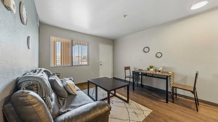 Inviting living room with a comfortable sofa, sleek coffee table, dining area, and bright natural light.