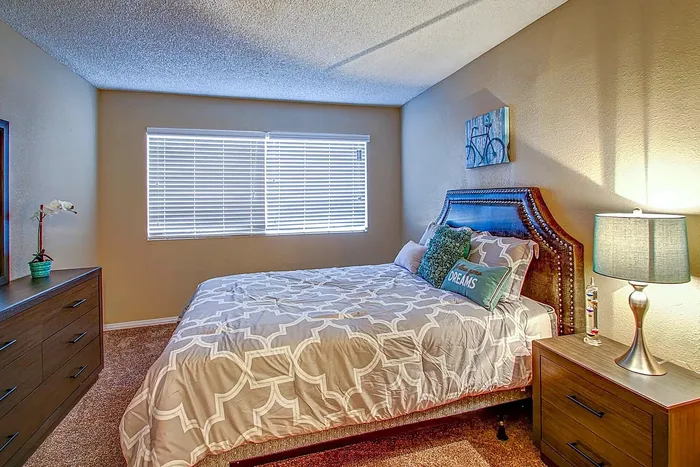 Inviting bedroom with a plush bed, stylish nightstand, and cozy decor.