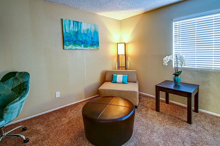 Inviting living space with a comfortable chair, modern lamp, and artistic decor.