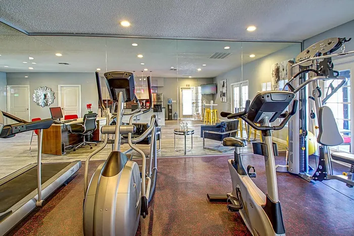 Modern apartment fitness center with state-of-the-art exercise equipment and a stylish lounge area.