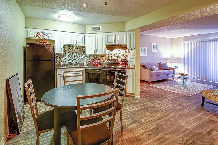 Inviting open-concept kitchen and living area with wood flooring, modern decor, and natural lighting.