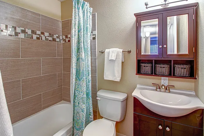 Elegant bathroom with modern fixtures, tile accents, and a decorative shower curtain.