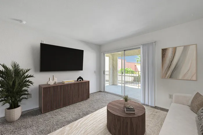 Elegant living room with modern decor, featuring a large TV, stylish wooden furniture, and access to a sunny balcony.