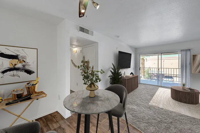 Bright and airy living room with elegant furnishings and large sliding doors leading to a balcony.