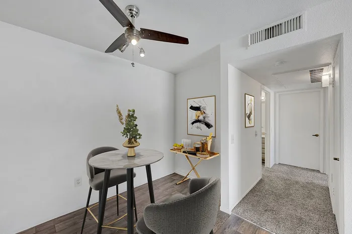 Stylish dining nook with a round table, modern chairs, and contemporary artwork in a cozy apartment setting.