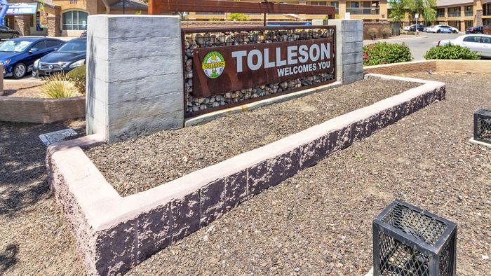Welcoming signage at the entrance to a vibrant community in Tolleson, featuring modern design and lush surroundings.