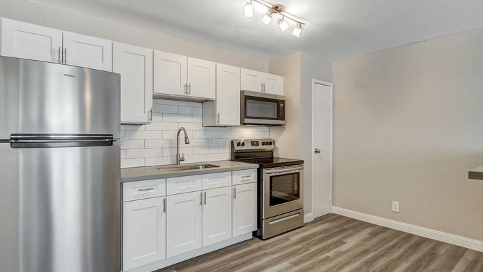 Modern kitchen with sleek stainless steel appliances, chic white cabinetry, and elegant lighting for a contemporary feel.