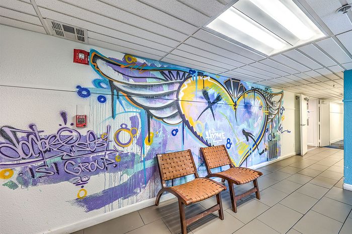 Vibrant lobby with colorful graffiti art and stylish seating, offering a modern and welcoming atmosphere.