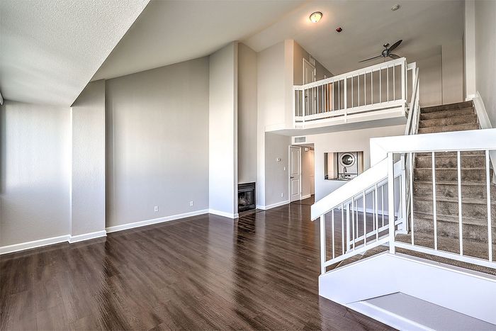 Elegant open-concept apartment featuring high ceilings, wooden floors, and a modern loft design with a stylish staircase.