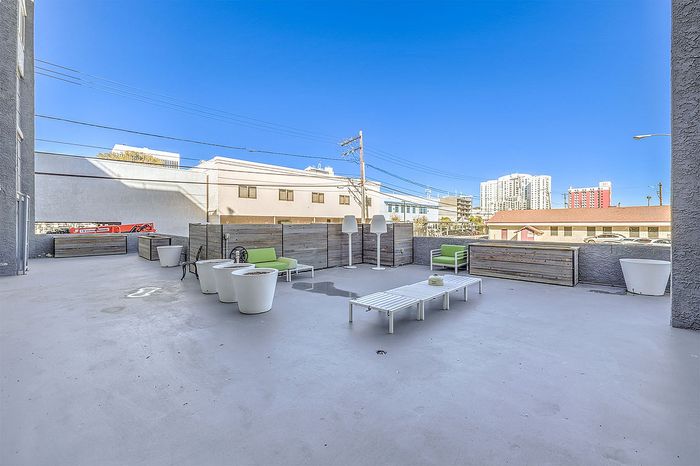 Spacious urban rooftop terrace with modern seating and vibrant city views, perfect for relaxation and social gatherings.