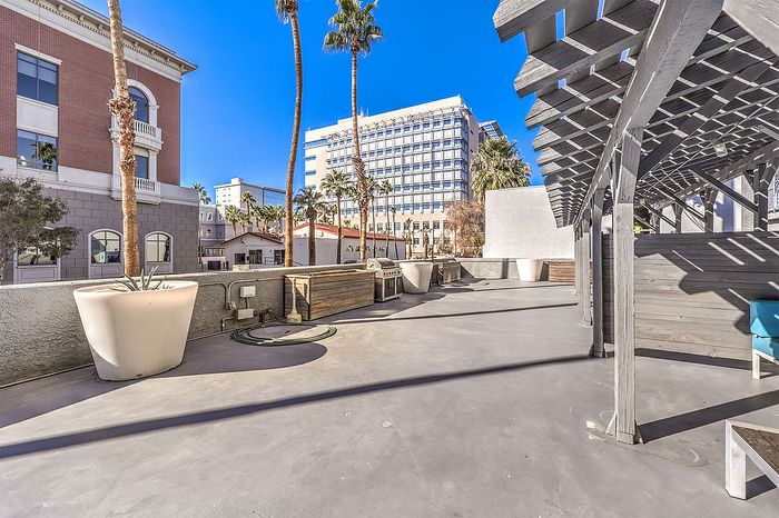 Modern rooftop terrace with pergola, ample seating, and city skyline views.