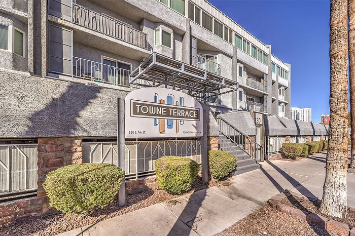Inviting exterior view of Towne Terrace apartments with modern architecture and lush landscaping under a clear blue sky.