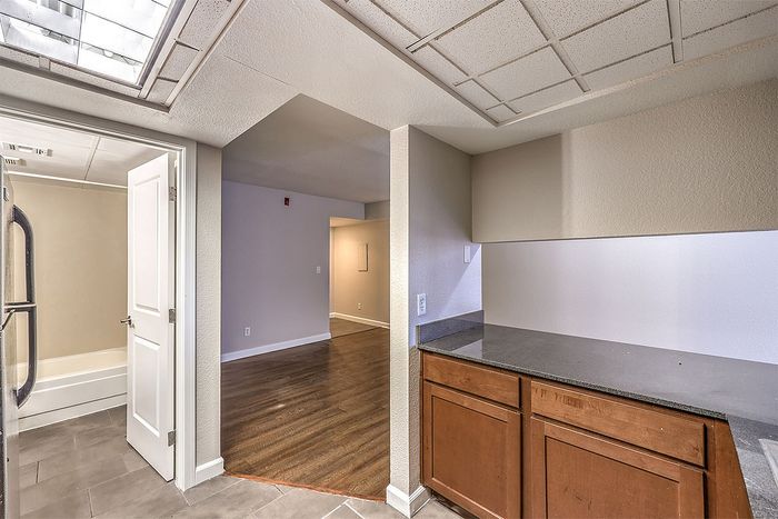 Inviting apartment space featuring elegant wooden floors, a convenient walk-through kitchen, and a bright bathroom with modern fixtures.