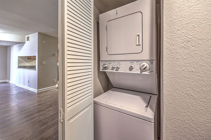 Chic apartment with in-unit laundry in a modern, open-concept living space featuring sleek hardwood floors.