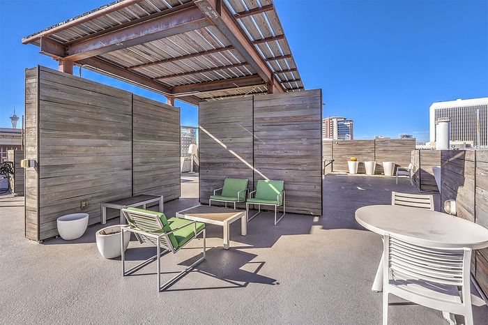 Inviting rooftop lounge with modern green seating, sleek wooden partitions, and breathtaking city views.