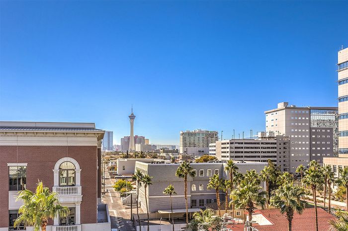 Panoramic cityscape view featuring modern buildings, palm trees, and clear blue skies creating an idyllic urban atmosphere.