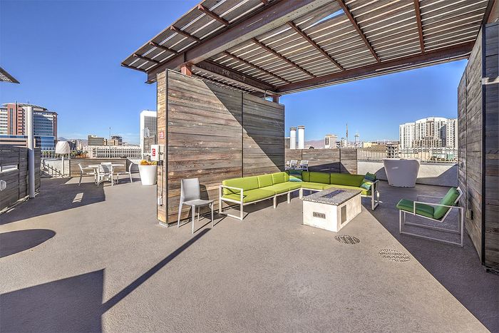 Chic rooftop terrace with stylish seating, modern architecture, and panoramic city views.