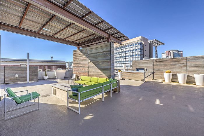 Chic urban rooftop patio with stylish seating, modern design, and stunning cityscape view.