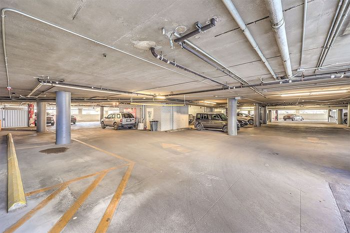 Spacious, well-lit underground parking garage featuring ample parking spaces and modern infrastructure.