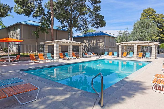 Inviting outdoor pool area featuring vibrant lounge chairs and shaded cabanas, perfect for relaxation and leisure.