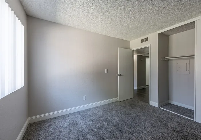 Bright and airy bedroom featuring plush carpeting, a spacious closet, and sleek modern design.