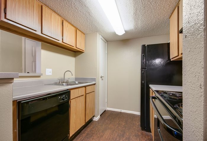 Cozy and modern kitchen with warm wooden cabinets, sleek countertops, and contemporary appliances.