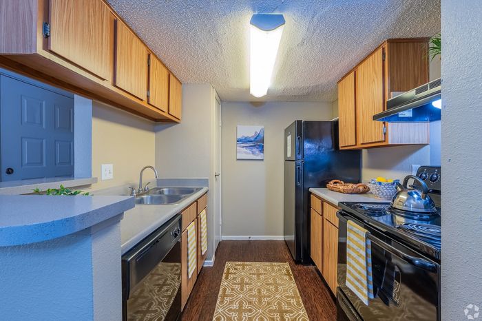 Charming kitchen with sleek black appliances, warm wooden cabinetry, and cozy lighting perfect for culinary adventures.