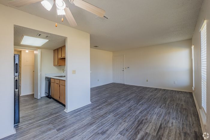 Inviting open-concept living area with elegant laminate flooring, bright kitchen with modern appliances, and abundant natural light.