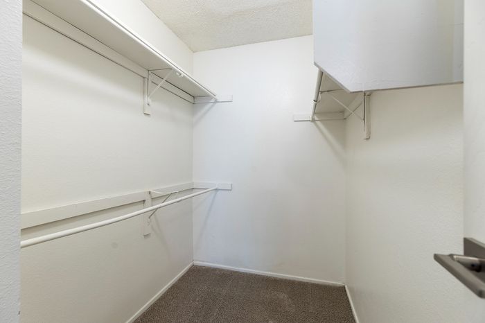 Spacious walk-in closet with ample shelving and clean, modern design.