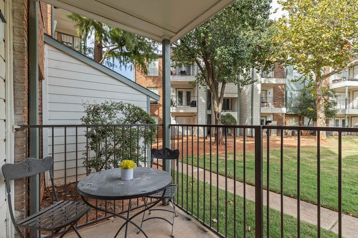 Charming apartment patio with cozy seating and lush garden views, ideal for relaxation in a peaceful setting.