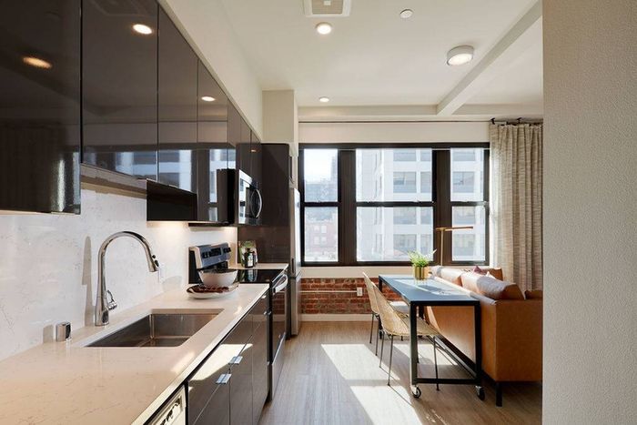 View of kitchen and living area below large windows in a Modera Berkeley apartment.