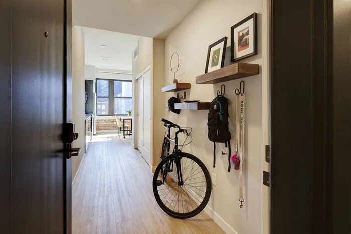 View of entry into Modera Berkeley home with bike and shelving