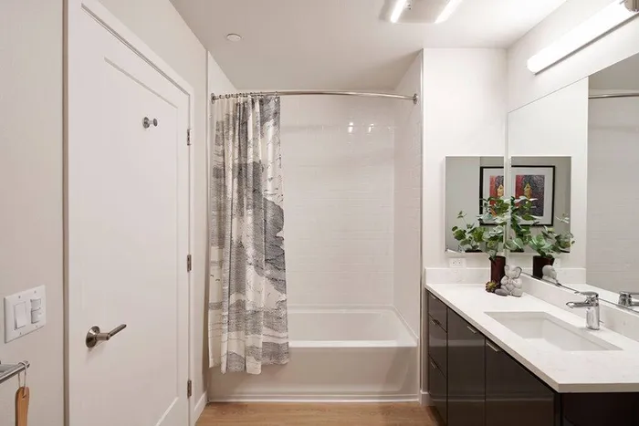 Tiled shower with large mirror and extra bathroom vanity mirror with storage  in a Modera Berkeley apartment.