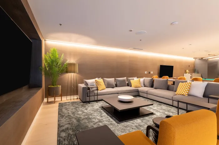 Large lounge area with large TV in game lounge  at Modera River Trail apartments.