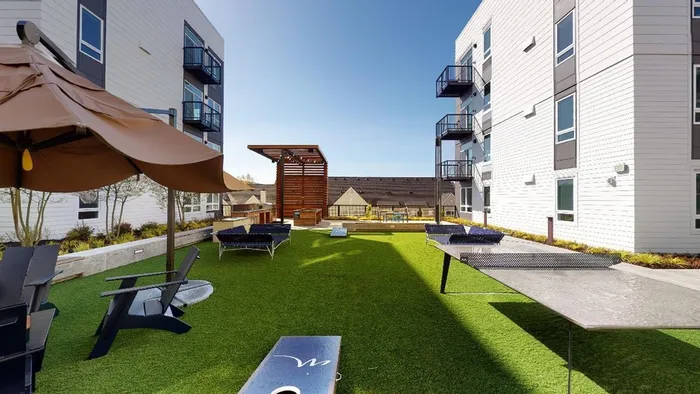 Cornhole in courtyard  at Modera River Trail apartments.