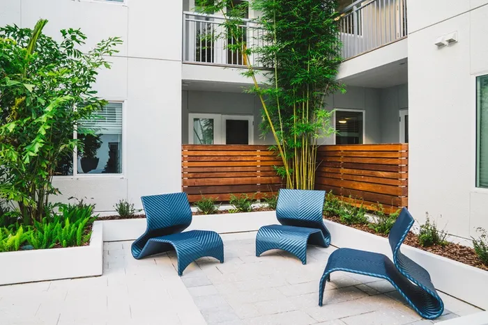Patio with seating amidst landscaping at Modera Creative Village | Orlando Apartments for Rent