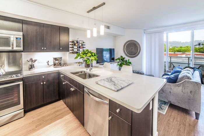 Modern kitchen with dark cabinets and quartz countertops at the Arroyo Residences in Walnut Creek