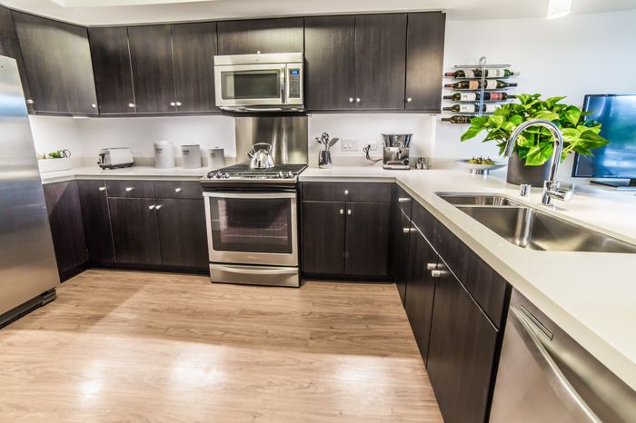 Modern kitchen with dark cabinets and quartz countertops at the Arroyo Residences in Walnut Creek