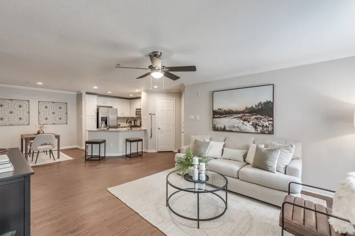 Living room with wood plank flooring leading to kitchen at Alister Galleria apartments houston texas