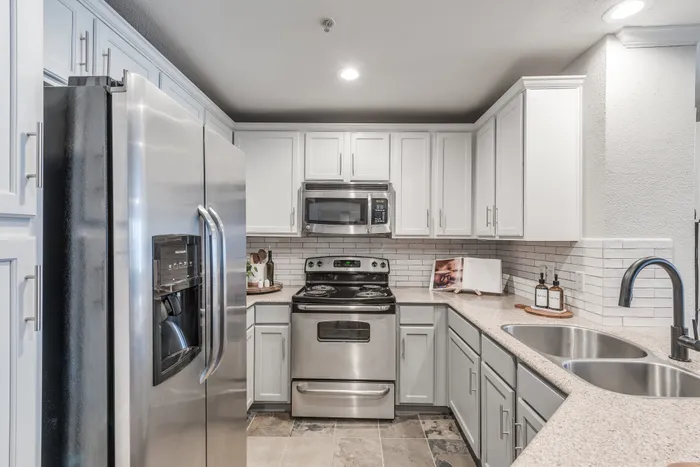 Kitchen area with tile flooring and stainless steel appliances at Alister Galleria apartments houston texas