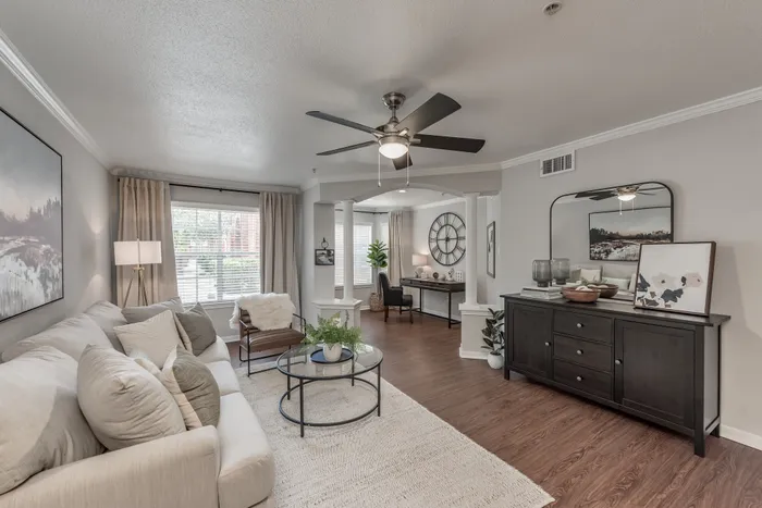 spacious living room with large windows and wood plank flooring with ceiling fan at Alister Galleria apartments houston texas