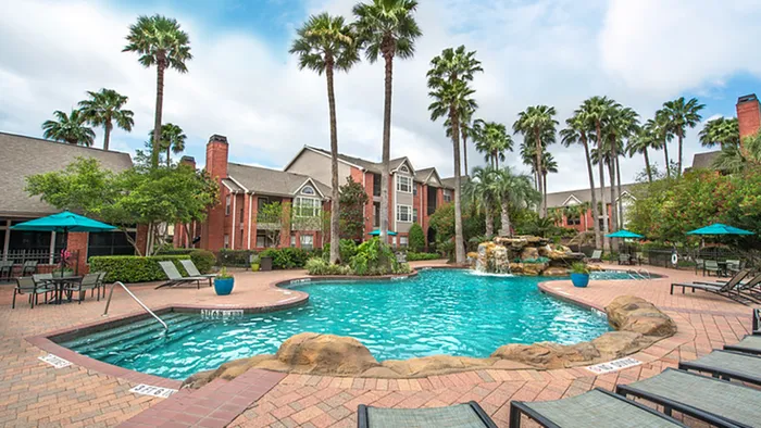 Resort-inspired pool surrounded by tall palm trees at Alister Galleria.