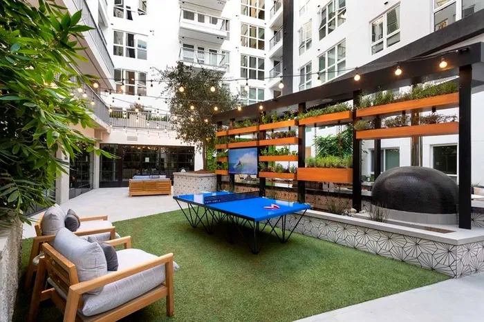 Outdoor games and lounge seating behind the outdoor kitchen in the courtyard at Modera San Diego