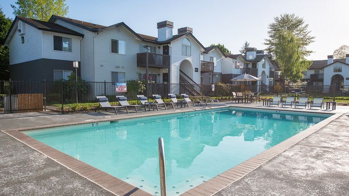 Pool area with chaise lounge seating and table and chair setting