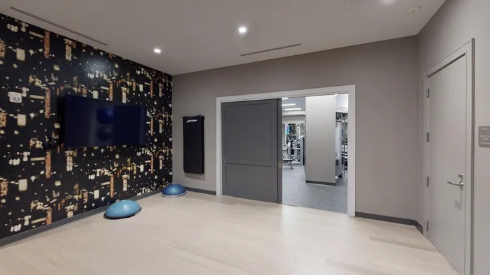 Club-quality fitness studio featuring a group fitness area and yoga/Pilates studio at Modera Needham Apartments