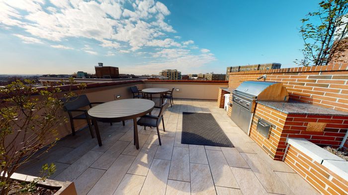 Outdoor grilling area with table and chairs