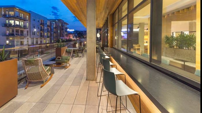 Indoor/outdoor lounge pull-up bar seating outside and lounge seating on the patio overlooking the neighborhood