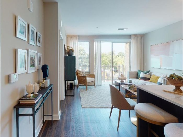 Living room at VERSO Founders Row showing balcony and pull-up bar seating at kitchen island